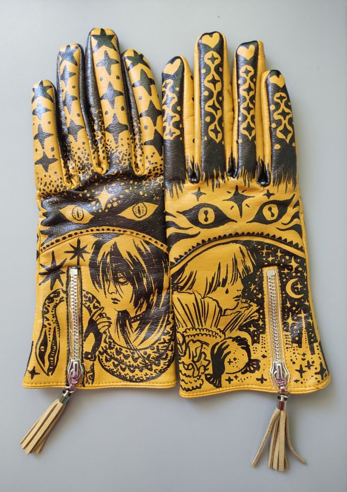 Upcycled yellow gloves with black drawings on them.