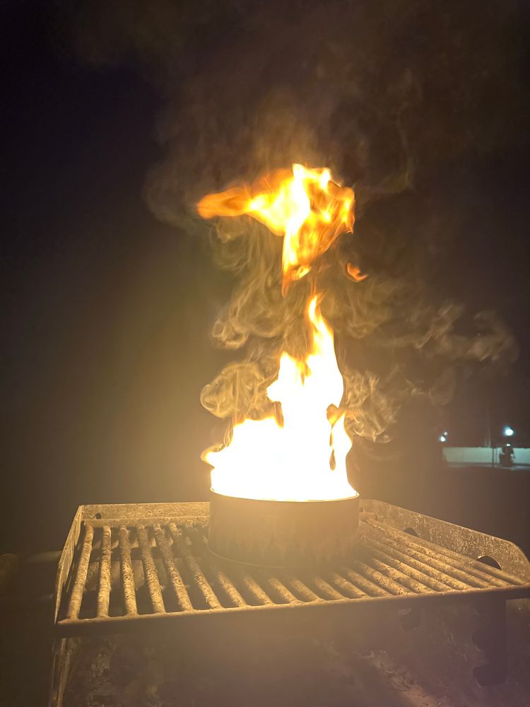 A portable campfire on top of a grill 