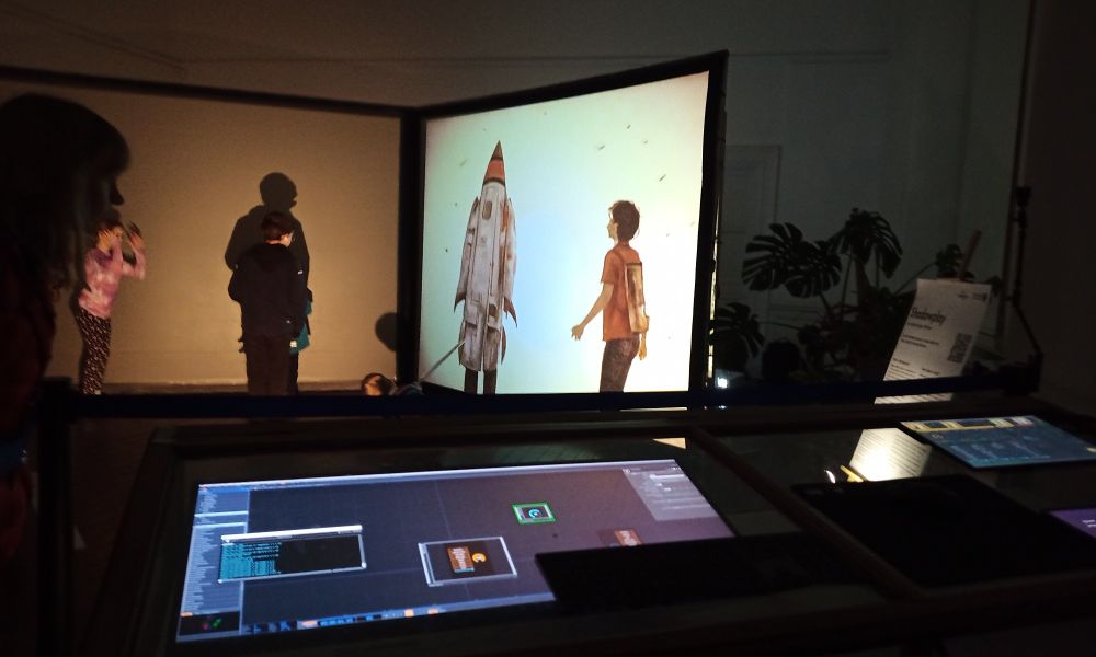 Children stand in front of a projection screen which is mirroring them with an illustrated rocket and person generated by AI in realtime