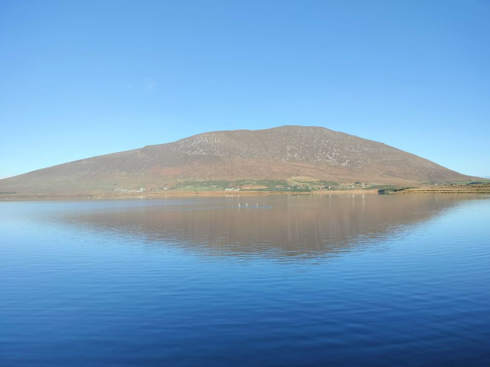 Slievemore, a mountain on Achill Island, reflected in a lake with some adolescent swans