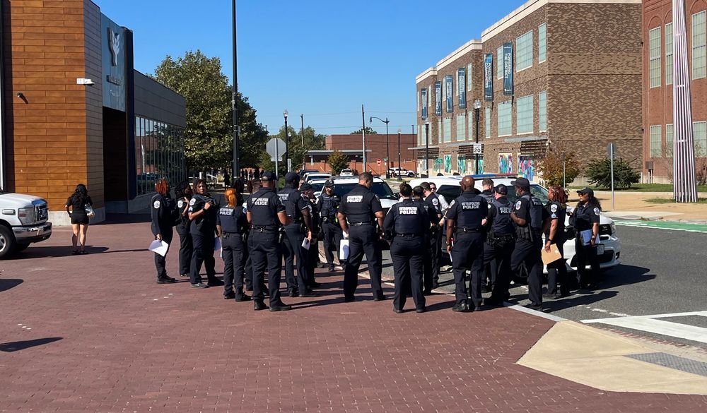 Group of about twenty MPD officers talking in a huddle outside Audi Field