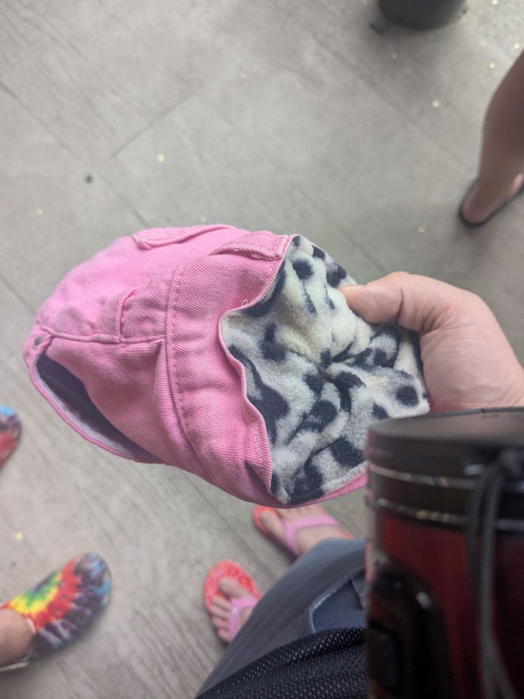 A pink and leopard print chalk bag attached to our pants being used as a pants pouch like from a fantasy game 
