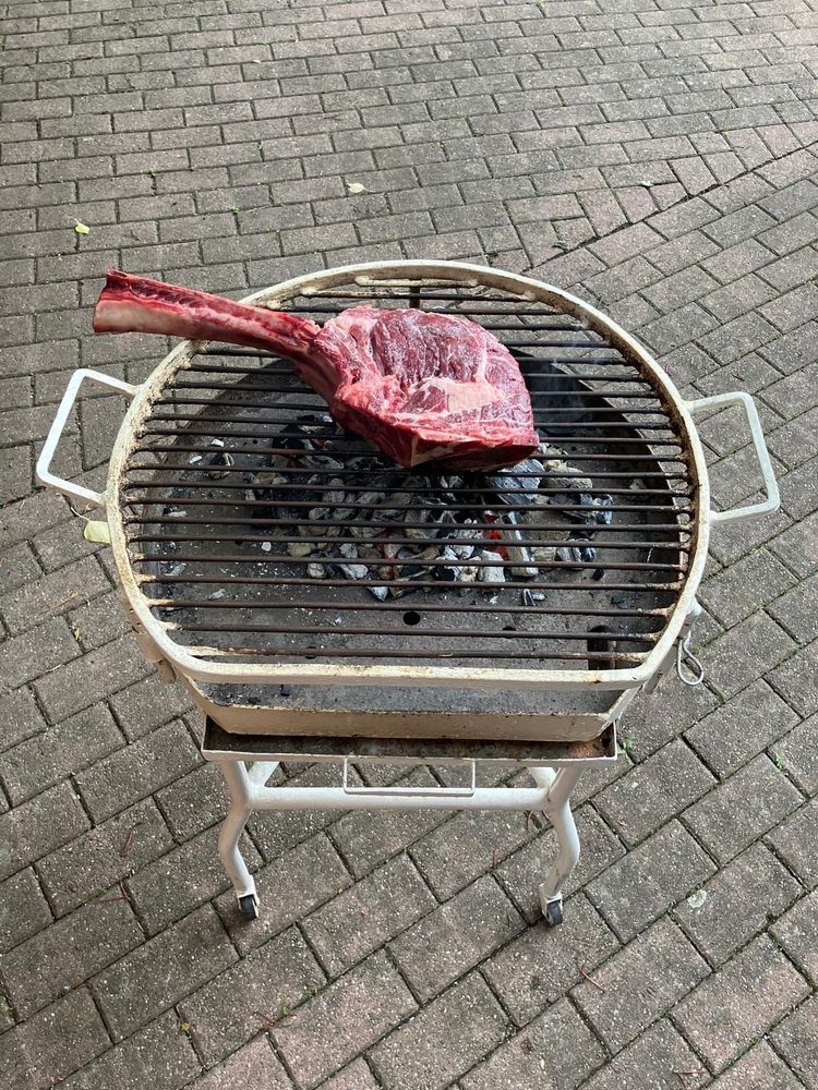A huge Tomahawk steak on a tiny grill. 