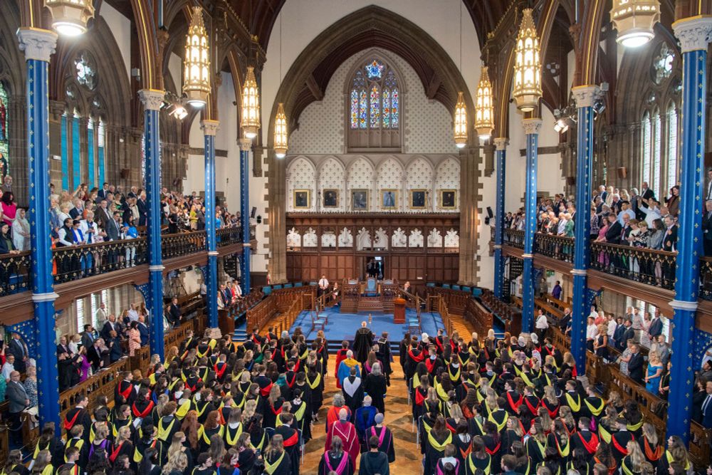 The Bute Hall filled with graduates wearing graduation robes.
