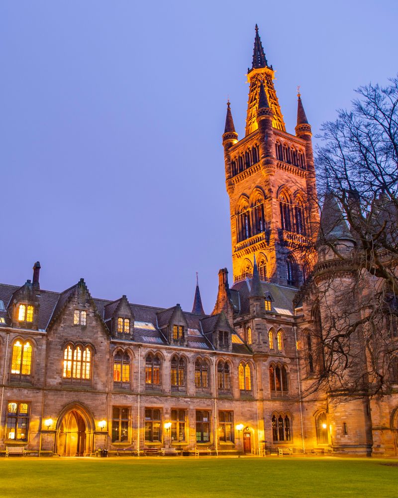 The Gilbert Scott Building and Tower early evening illuminated as seen from the East Quadrangle