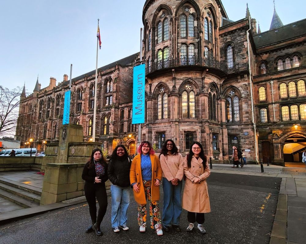 A group of people standing outside of the univeristy of glasgow main building 
