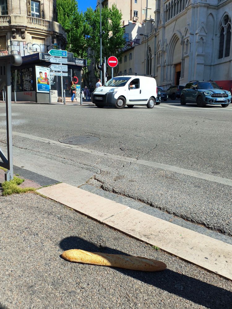 A baguette abondonned on the floor in a intersection of Marseilles 