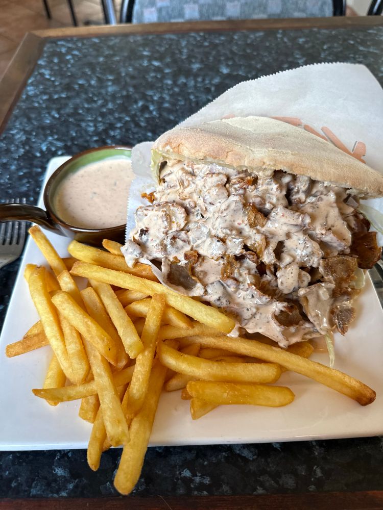 Photo of a döner kebab Swedish style with fries and a dip sauce.