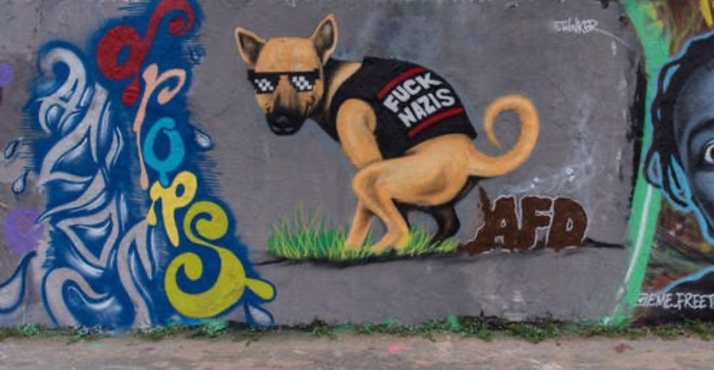 Graffiti eines Hundes mit "Fuck Nazis" Shirt, der einen Haufen auf die #AFD scheißt. Feiner Hund!