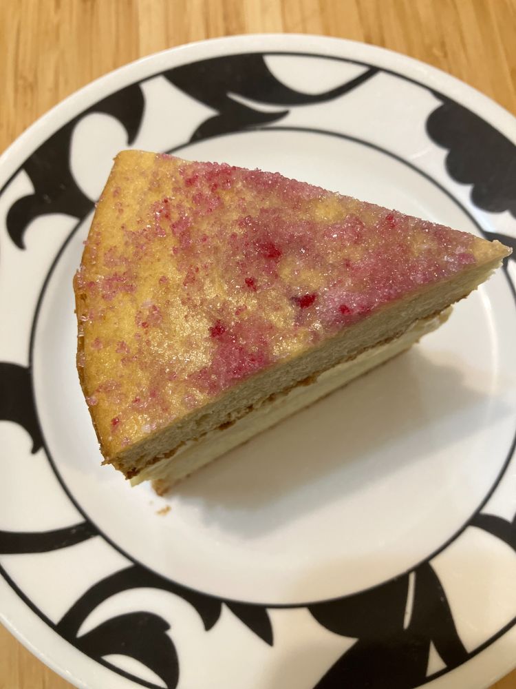 A slice of cake topped with red sugar. 