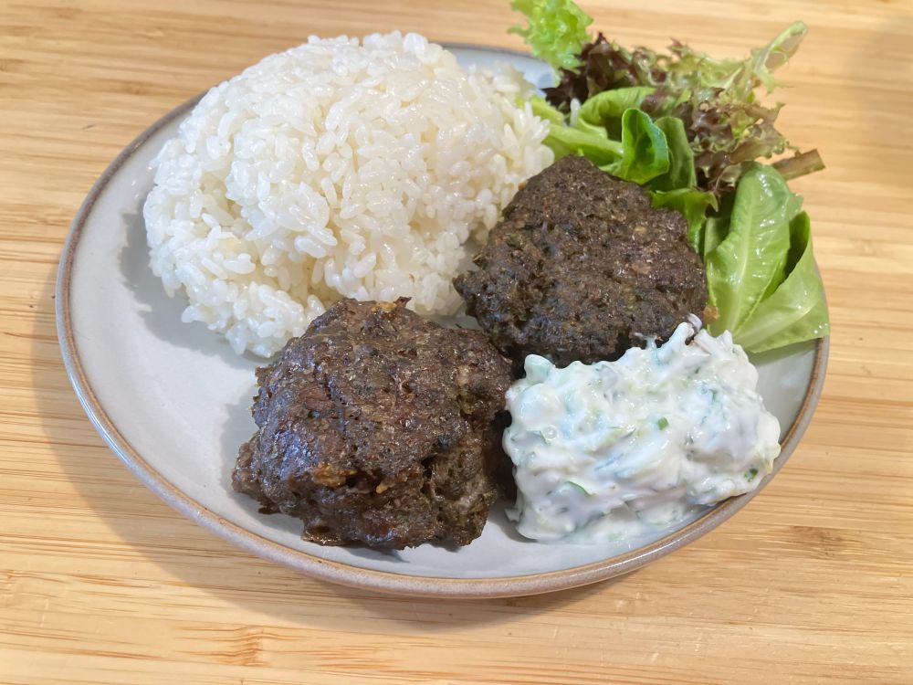 Dark meat patties with rice and a yogurt sauce. 