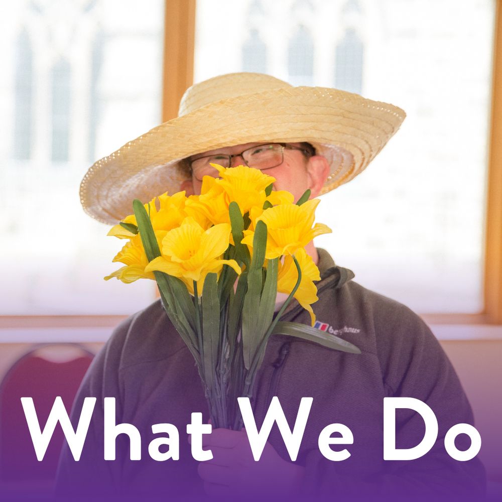 Image of a purple participant holding flowers. The bottom text says 'What We Do'