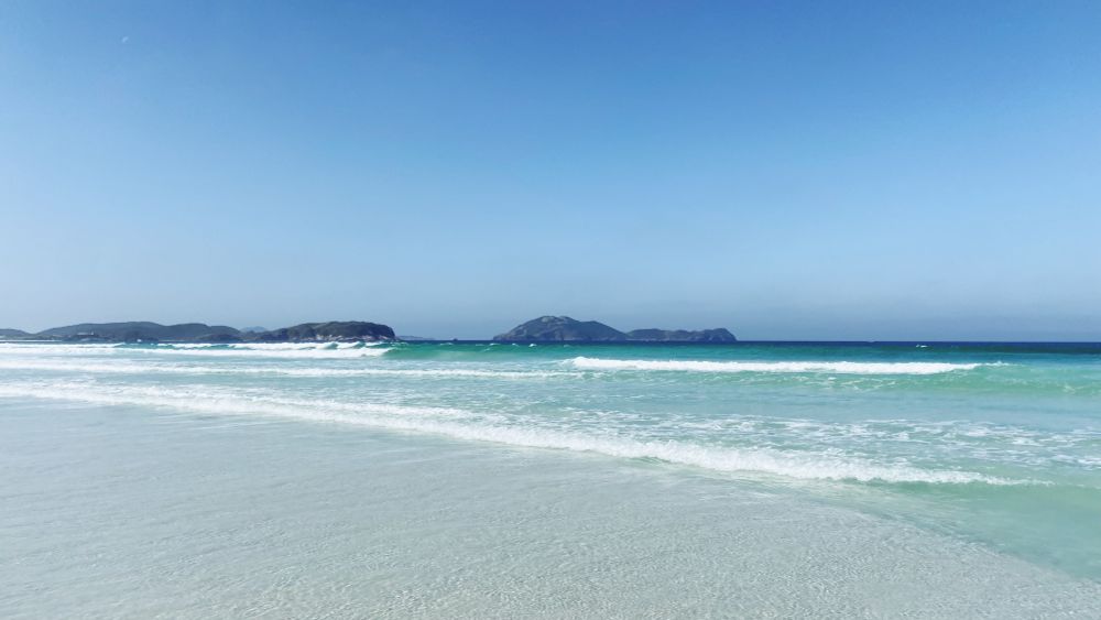 praia das dunas em cabo frio-rj. água cristalina, ao fundo montanhas e céu azul