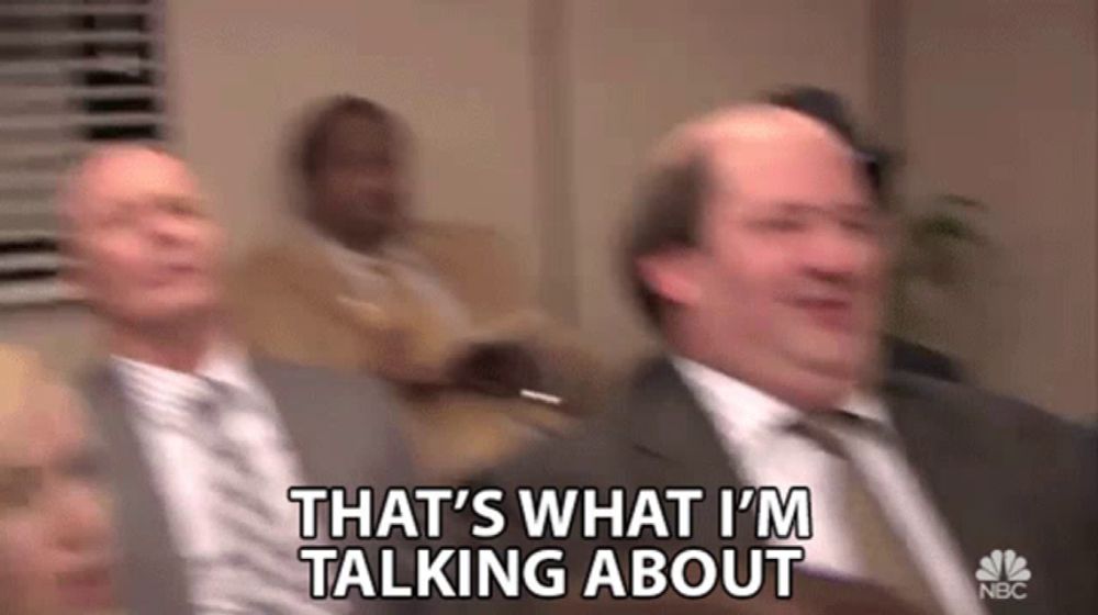 a group of men in suits and ties are sitting in a room and talking about something .