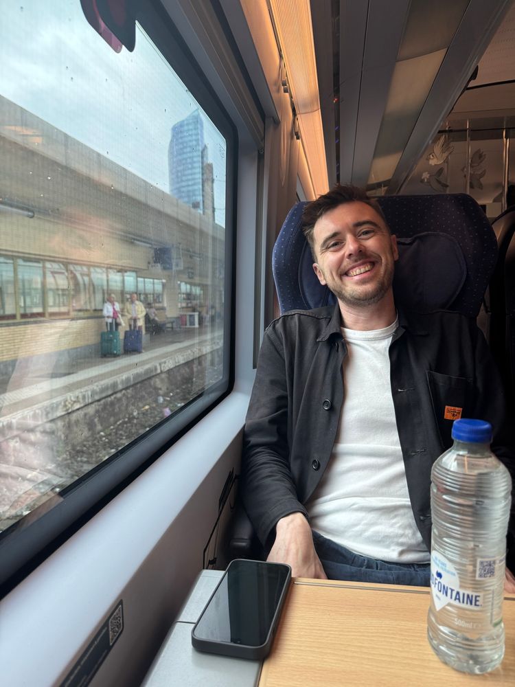 A smiling man on a train in Europe.