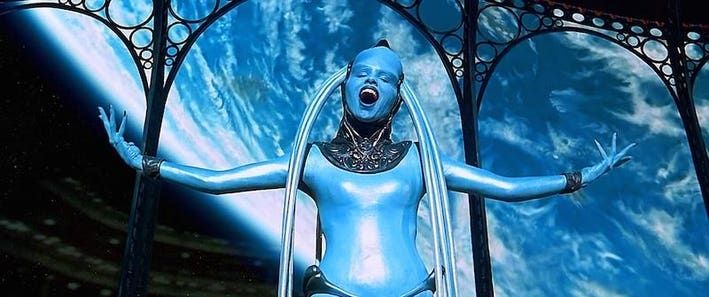 The Fifth Element's blue opera singer, Diva Plavalaguna, singing with her arms wide open with a blue planet as a backdrop.