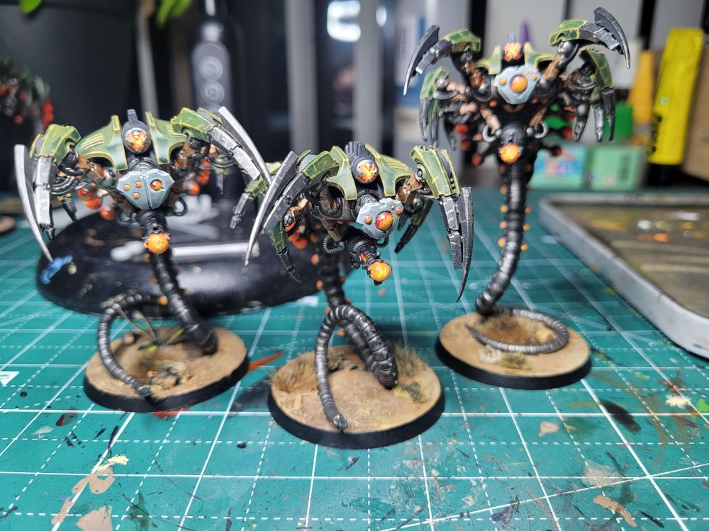 3 canoptek wraiths, painted in a green and orange Mephrit Dynasty scheme