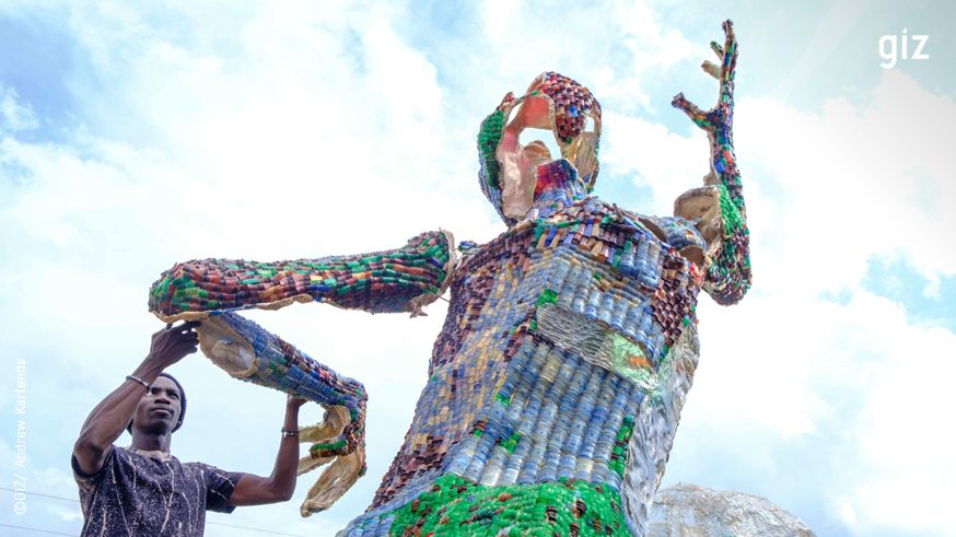 Man working on his statue built from plastic waste