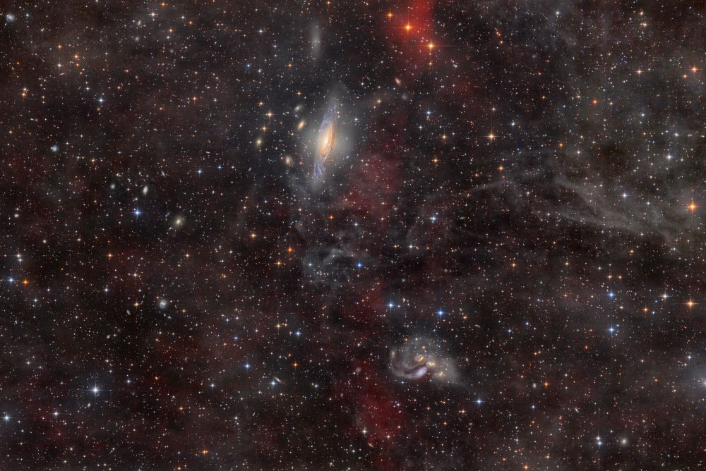 A large spiral galaxy seen from the edge together with a galaxy group closely packed 