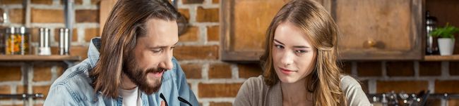 Male and female in a small business retail setting, looking at a computer