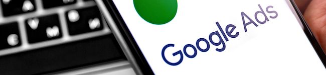 Google Ads logo on a smartphone screen next to a keyboard