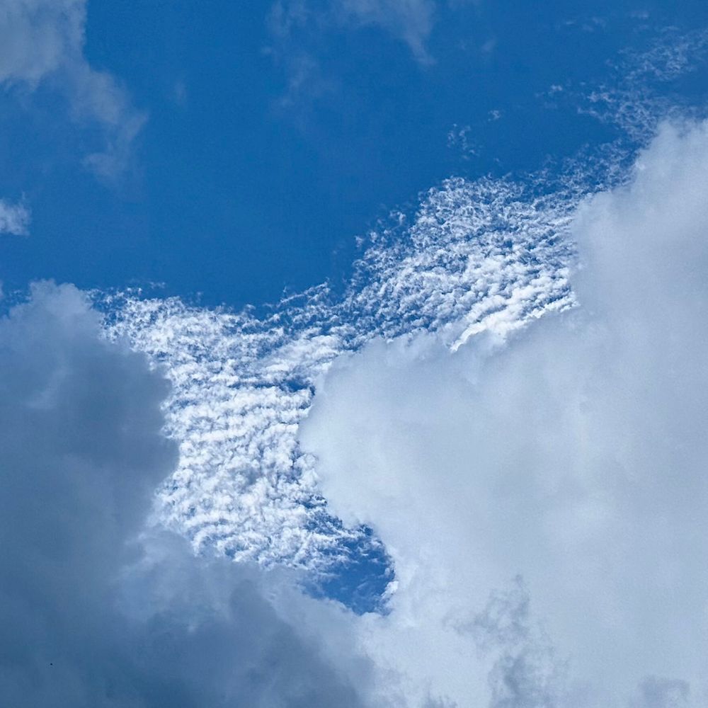 some altocumulus clouds peeking out from behind some cumulus clouds (though to be fair i am very bad at recognizing cloud types)