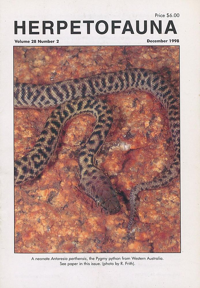 The front cover of a journal (Herpetofauna), featuring a brown and black snake (a Pygmy Python) on a red rock. 