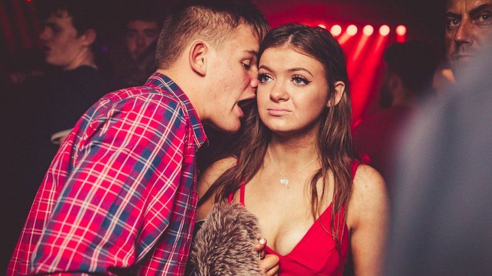 A women being bothered by a man in a nightclub