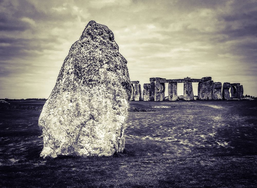 Sepia coloured image of Stonehenge with the heel stone in the left foreground 