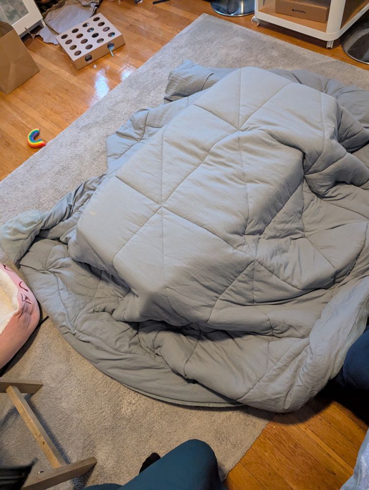 The start of a kotatsu - the blanket is draped over the base of the table, but the top table is not on yet. 