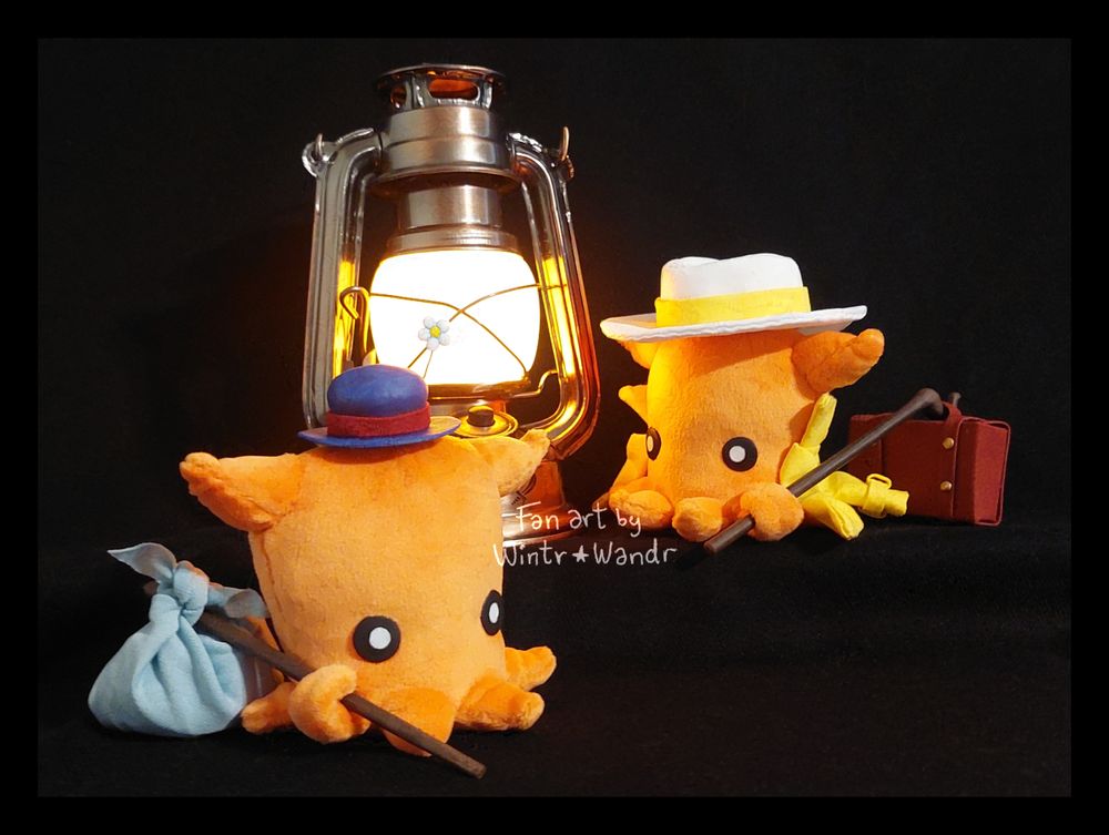 A photograph of a pair of small Octopuff Traveler plushies. One of them is wearing a white hat and yellow coat, which is affixed to it like a cape. It's holding a tiny briefcase attached to the end of a stick. The other Octopuff is holding a small bag at the end of a stick and wearing a blue hat with a flower sticking out of it. In the photo with them is a battery operated lantern, which is lit up and glowing with yellow light.