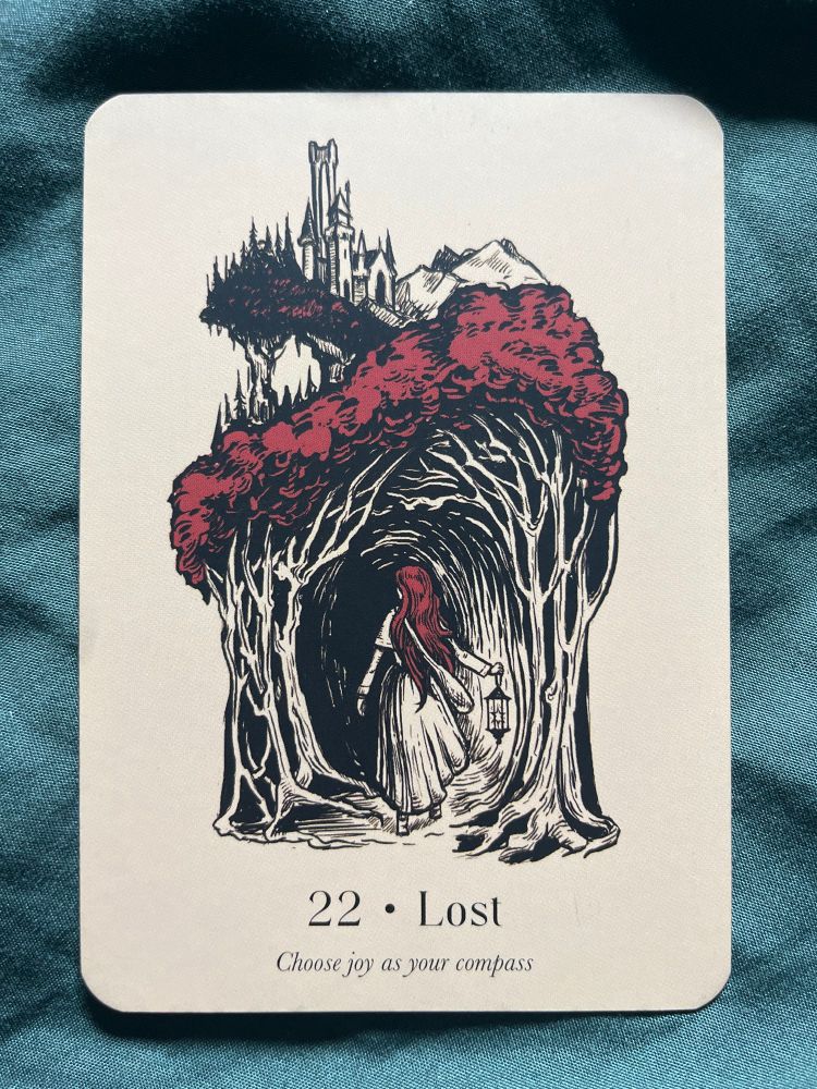 An oracle card showing a red haired woman in a dress holding a lantern, entering a dark wood below a castle upon a hill