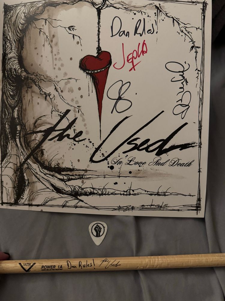 A signed poster, a guitar pick from the opening band, and an autographed drumstick.