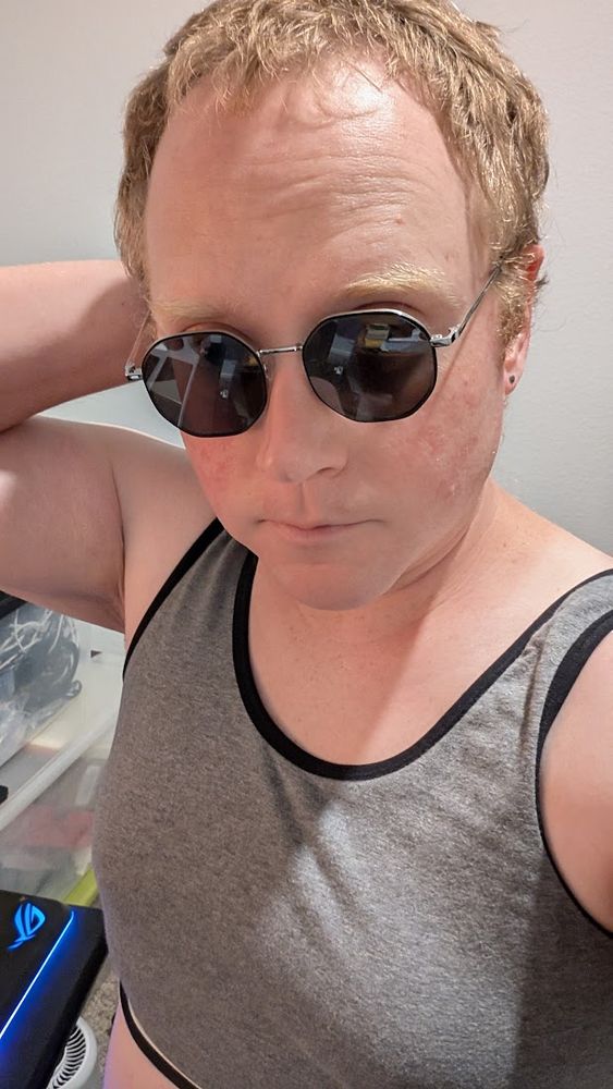 me in a gray athleticy top wearing octagonal mirrorshades I look confused because instead of posting this I should be finding my regular glasses.
