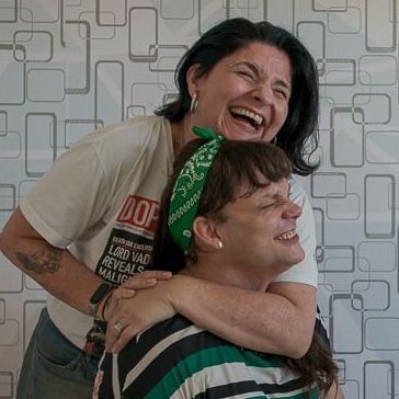 Two women, one transgender, laughing in happiness.