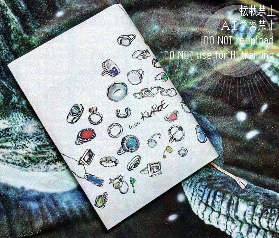 ブックカバーを付けた小説「クロエとオオエ」
ブックカバーは「OSTERIA BUCO BOLOGNESE」さんで貰える限定品。小説「クロエとオオエ」に登場するジュエリーが複数描かれています。

/転載禁止/ＡＩ学習禁止/DO NOT reupload.DO NOT use for AI training.