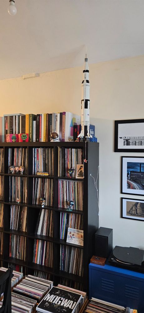 Record shelving in a room with a Lego model of Saturn V on top