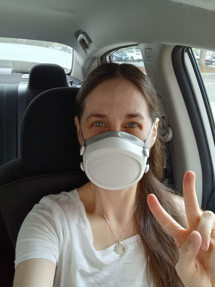 A photo of me in a Flo Mask and making a "peace" sign with my hand.