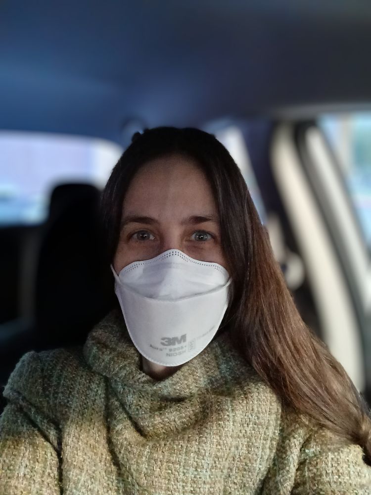 A photo of me in my car wearing a coat and a 3M Aura respirator mask.