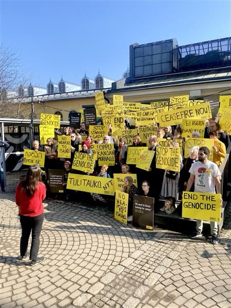 Mielenosoittajia ja kylttejä, joissa vaaditaan tulitaukoa Gazaan.