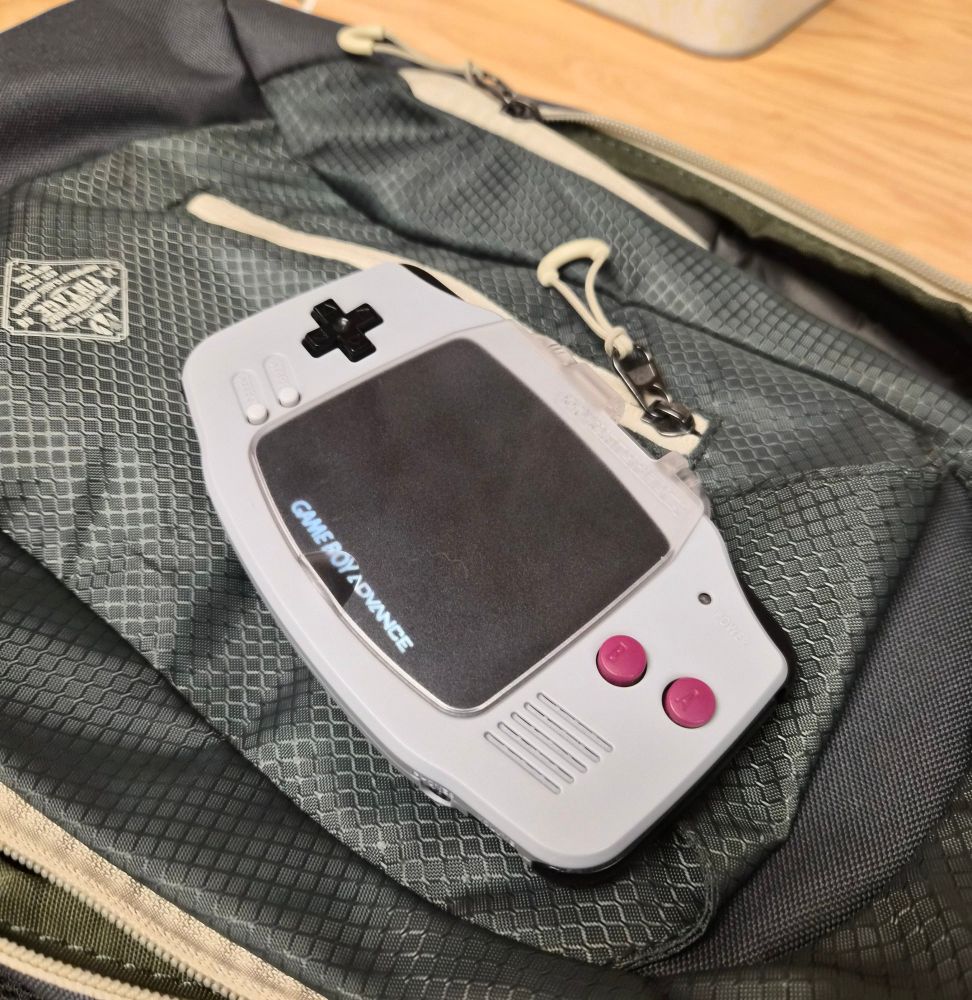 A Game Boy Advance with an IPS screen installed and new buttons/shell. There is a clear screen flip cover on it that attaches to the slots on the top of the device.