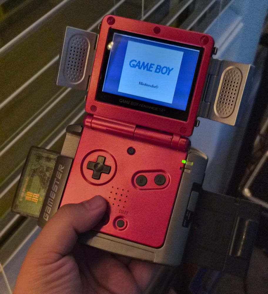 GBA SP in a Radica Game Changer and folding external speakers attachment. There are three cartridges attached to the Radica (Wario Land 3, GB Camera, and Pokémon Pinball). It won't work with multiple GB carts.