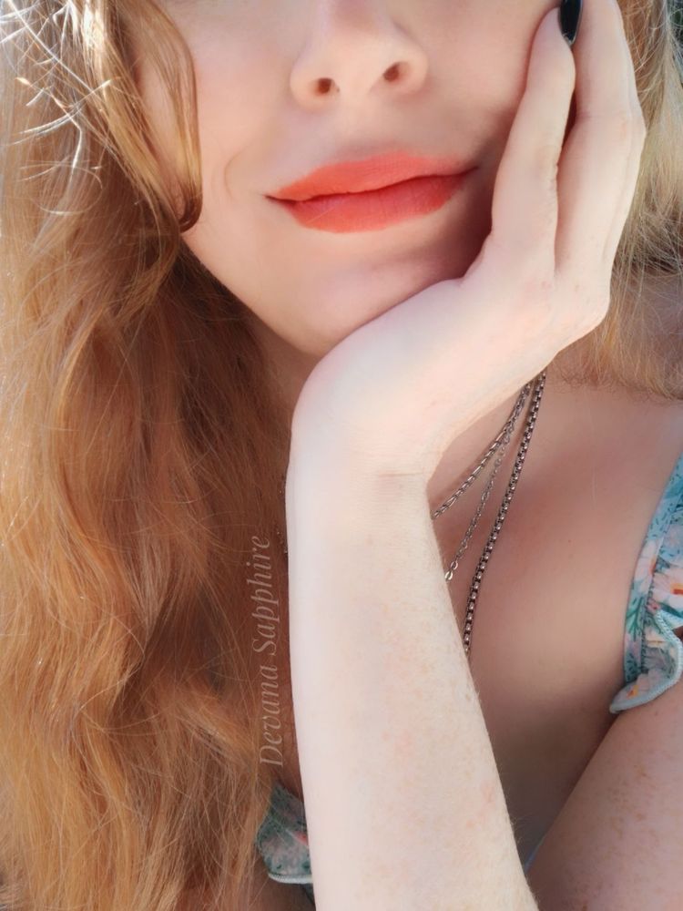My hand cupping my chin. I'm wearing cute coral lipstick. 