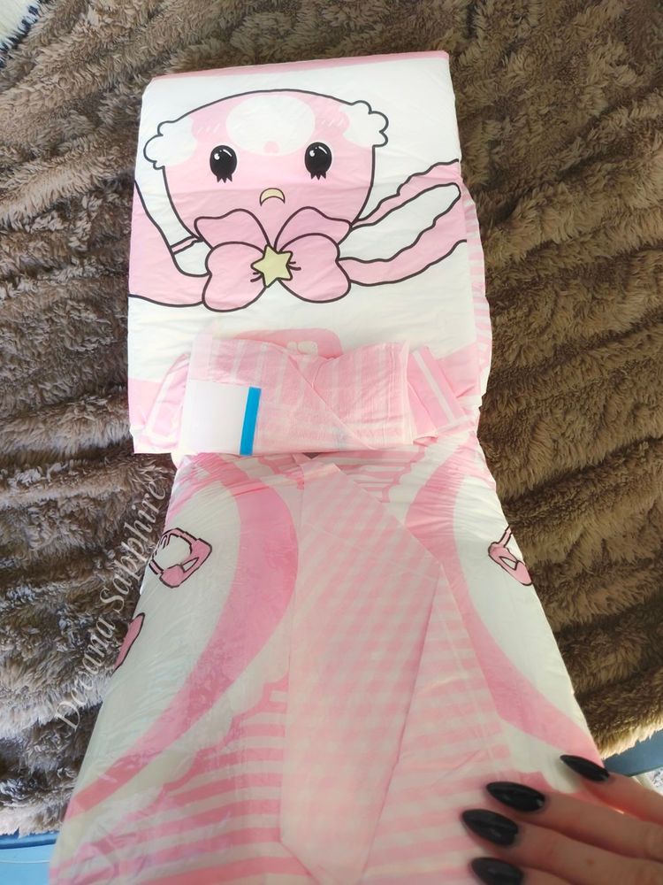 My hand holding a pink bunny diaper. I've unfolded one side.