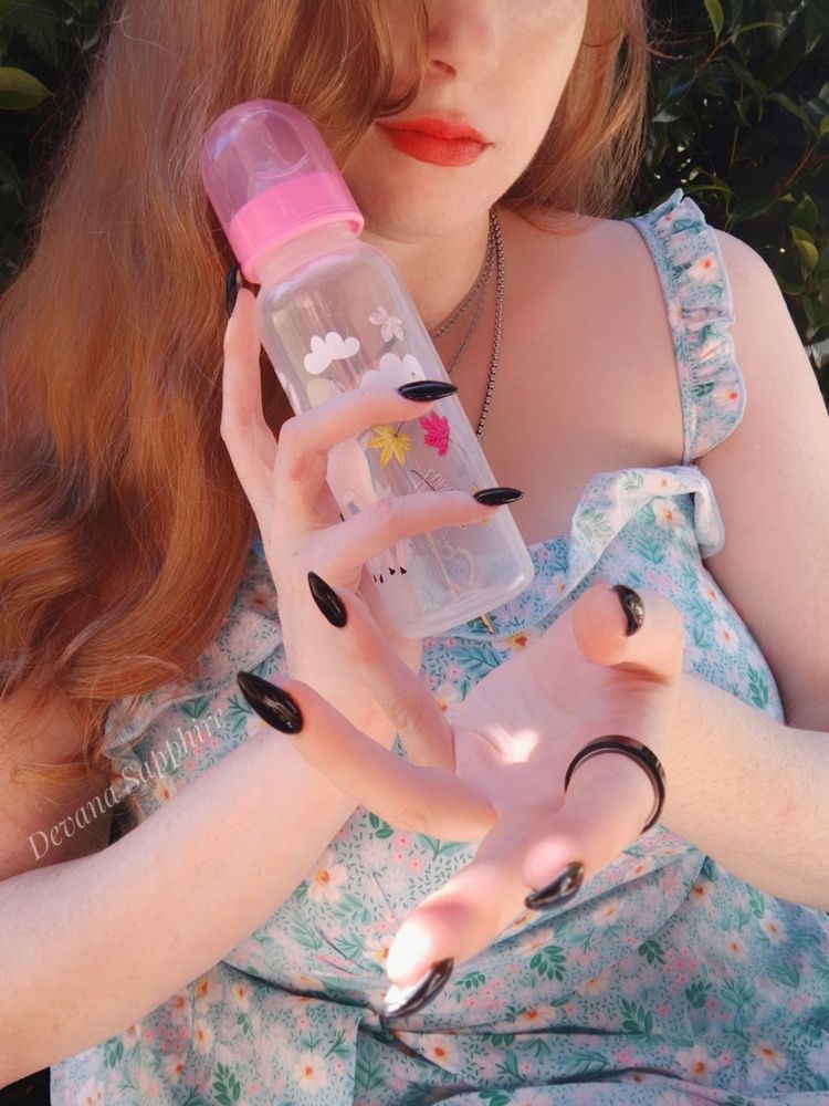 Me sitting outside in a blue green sundress with my hair down. In one hand I'm holding a cute bottle while gesturing for you to join me with the other. 