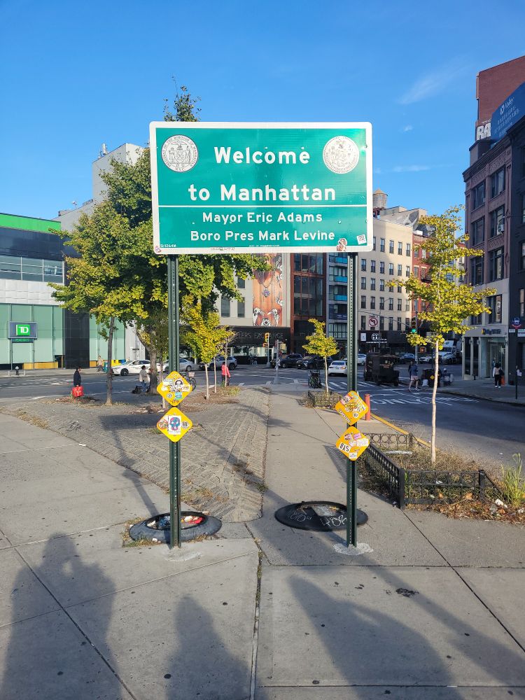 Sign reads

Welcome to Manhattan

Mayor Eric Adams