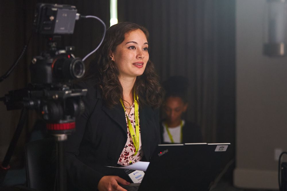 A woman in a black blazer with a laptop