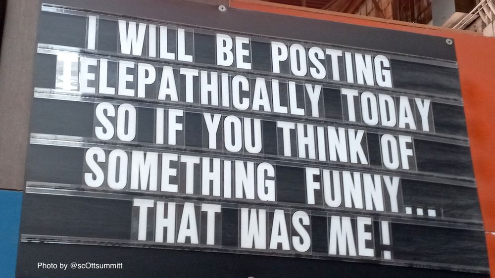 A photo of a sign with a dark background and white letters that say “I will be posting telepathically today so if you think of something funny...that was me!” Photo by scOtt summitt, taken in Chicago.