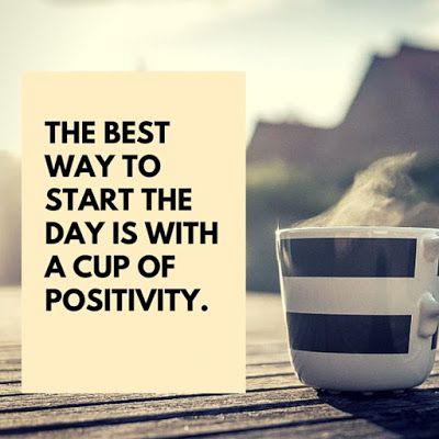 Black letters on a white card reading "The Best way to start the day is with a cup of positivity" sitting near a hot cup of coffee in the morning sun.