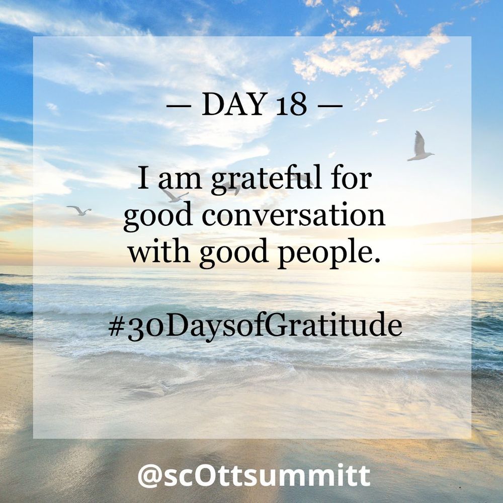A picture of a beautiful white beach with rolling blue waves under a bright blue & sunny sky filled with seagulls. An opaque white box with black letters reading "Day 18 - I am grateful for good conversation with good people.“ and the hashtag #30DaysofGratitude